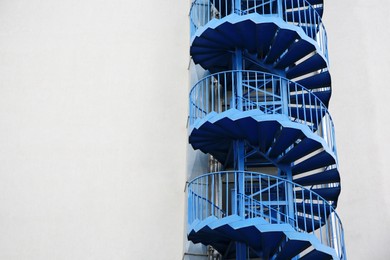 Photo of View of modern metal empty fire escape ladder near building outdoors. Space for text