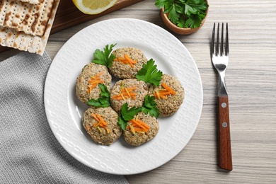 Flat lay composition with plate of traditional Passover (Pesach) gefilte fish on wooden background