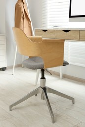 Photo of Stylish office chair at workplace in room. Interior design