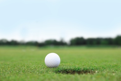 Photo of Golf ball near hole on green course