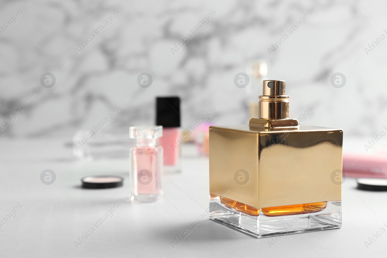 Photo of Bottle of perfume on table against marble background. Space for text