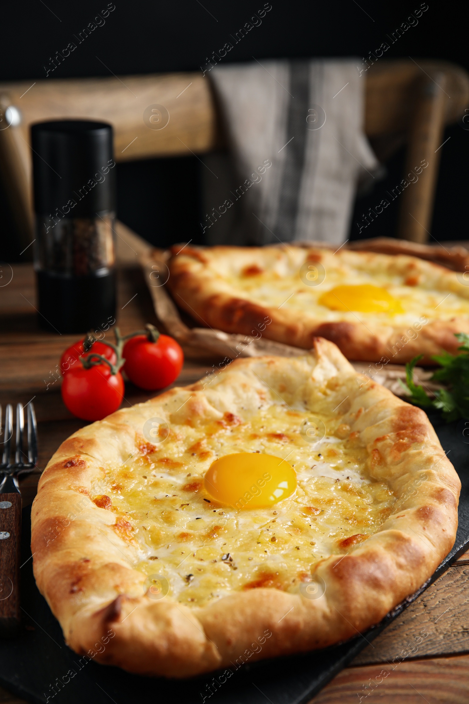 Photo of Fresh delicious Adjarian khachapuris served on wooden table