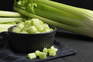 Bowl of fresh cut celery on grey table, closeup