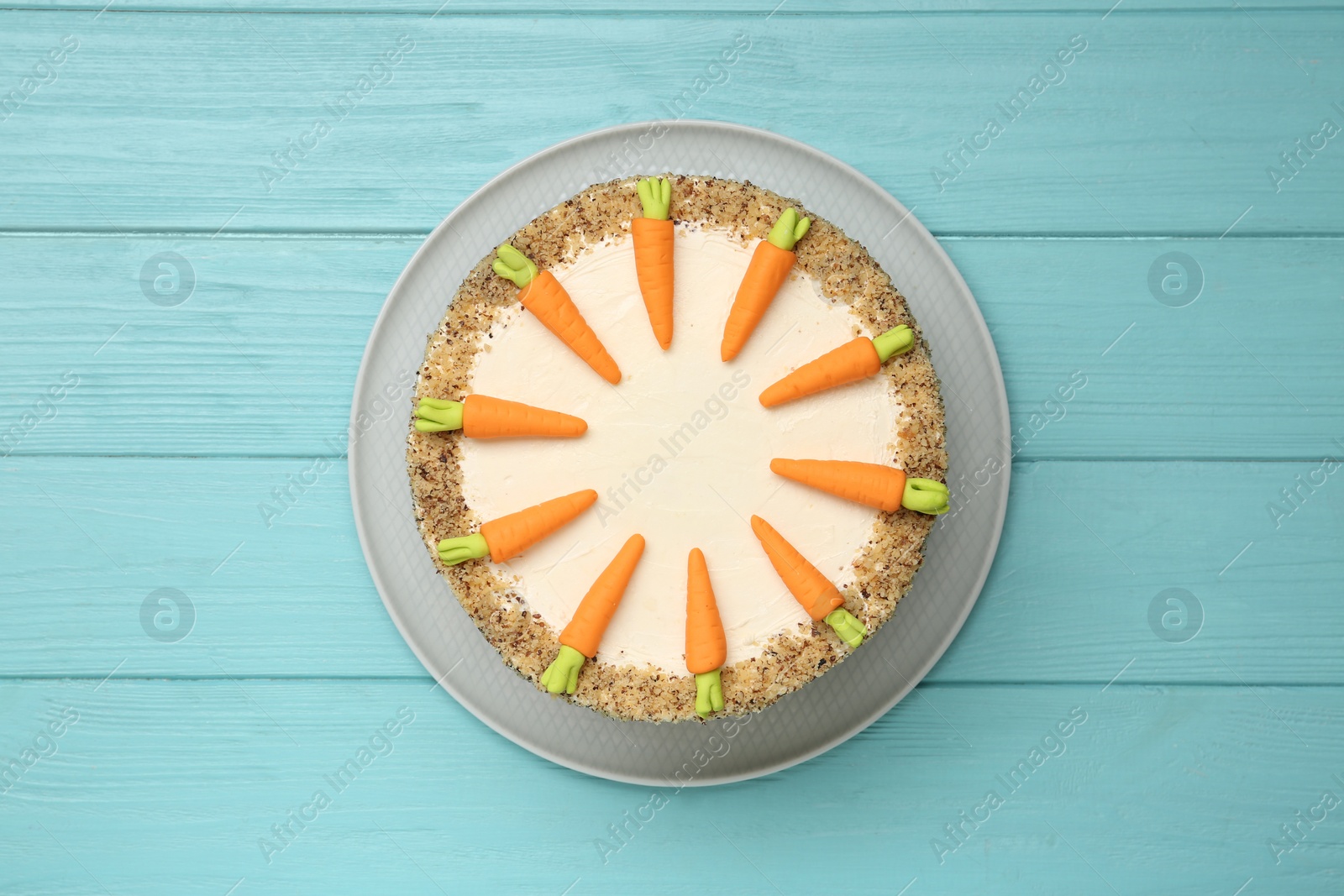 Photo of Dish with delicious carrot cake on blue wooden background, top view