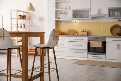 Photo of Modern kitchen interior with stylish wooden table