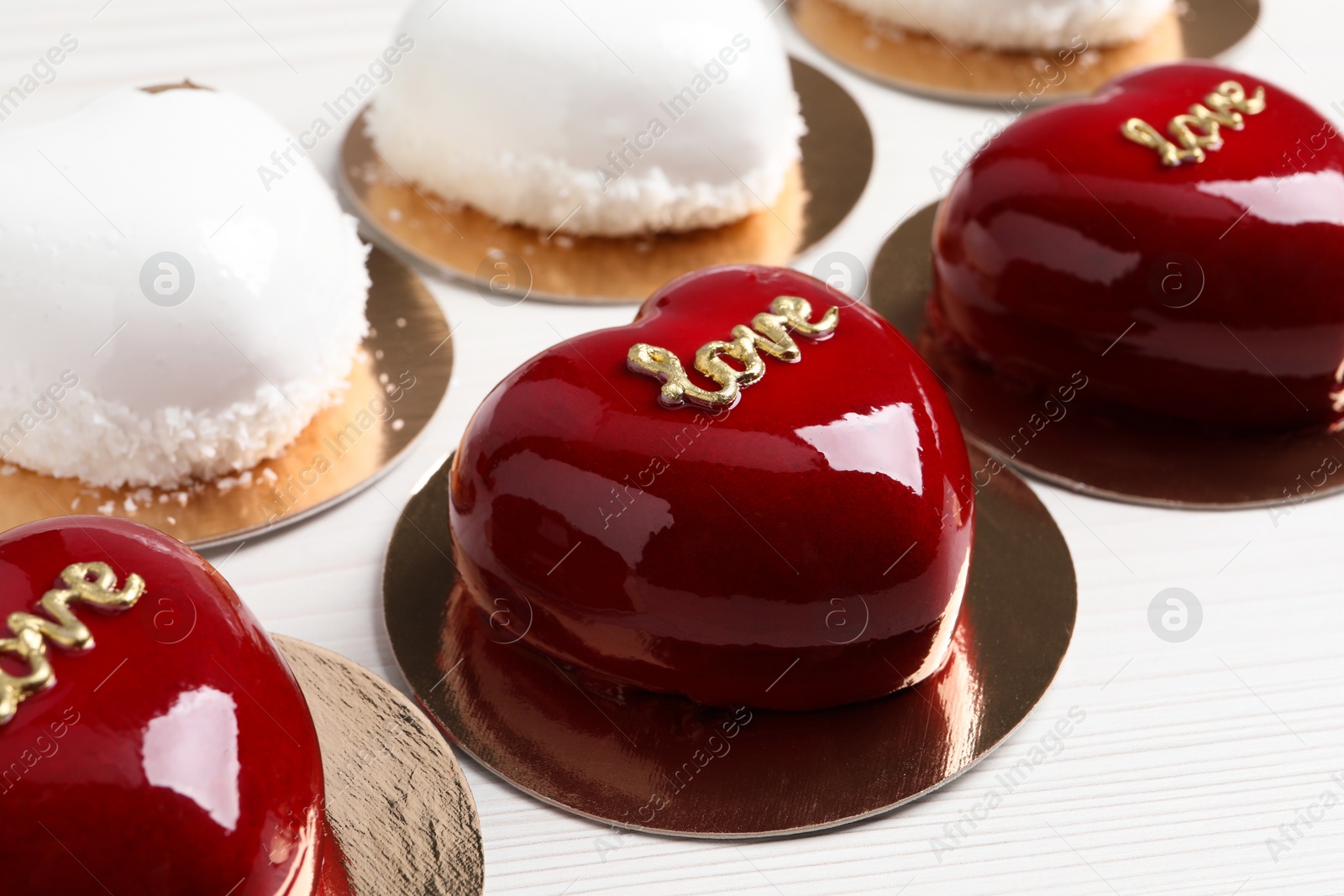 Photo of St. Valentine's Day. Delicious heart shaped cakes on white wooden table, closeup