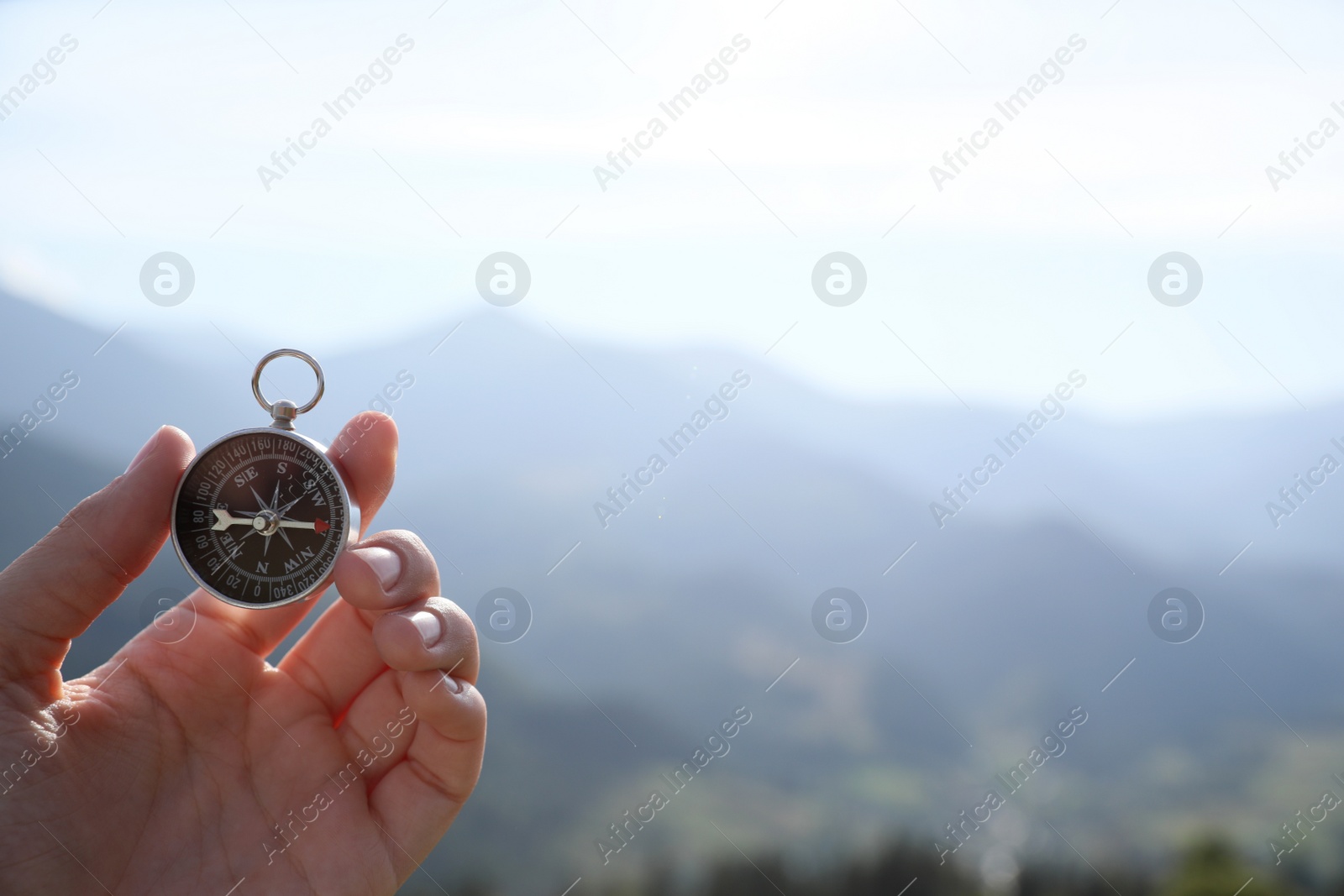 Photo of Woman using compass during journey in mountains, closeup