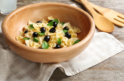 Bowl with delicious pasta salad on table