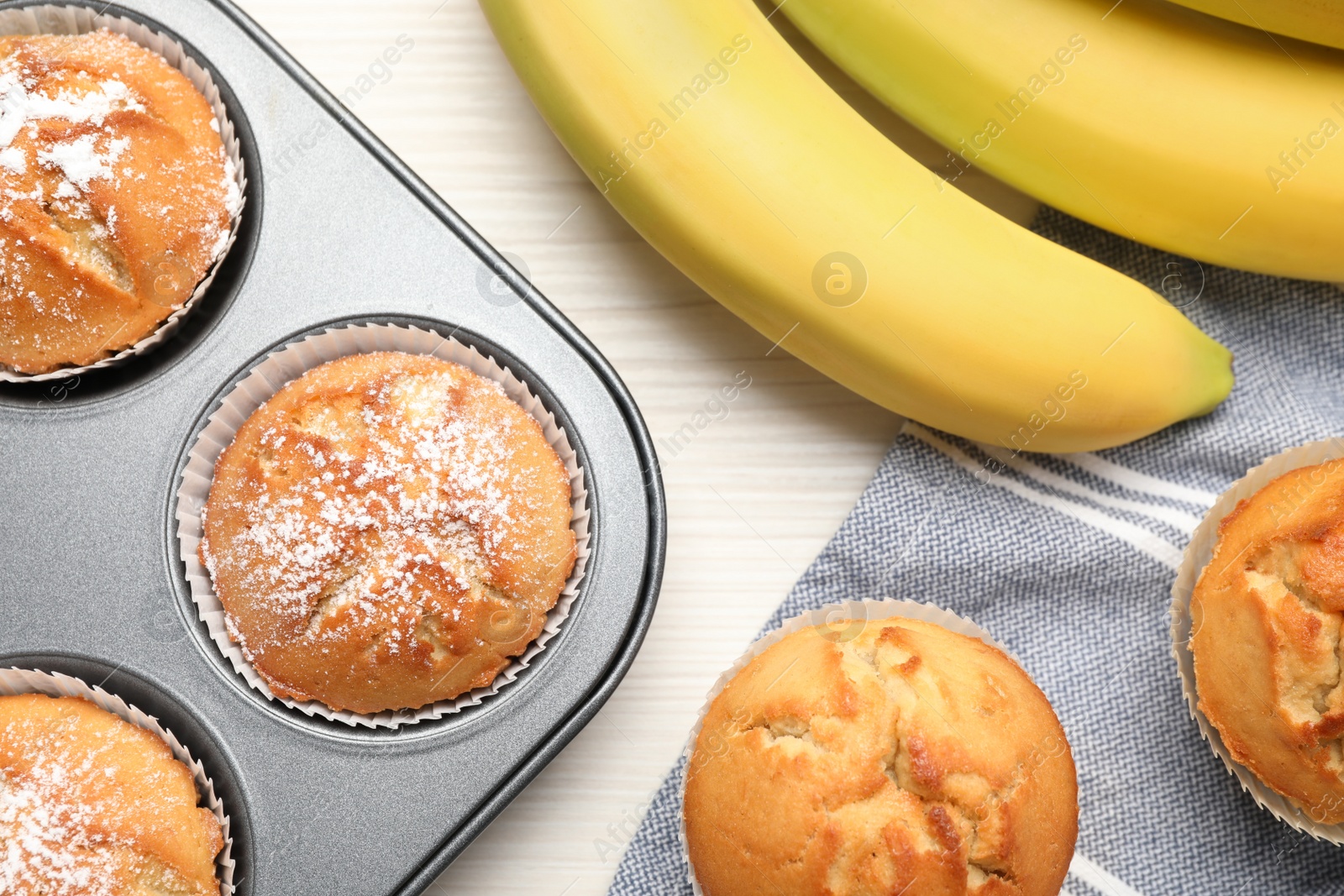 Photo of Flat lay composition with tasty banana muffins on white wooden table