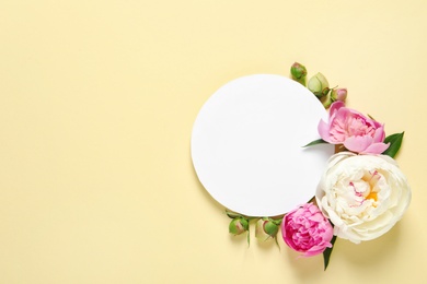 Photo of Fresh peonies and empty card on color background, flat lay with space for text