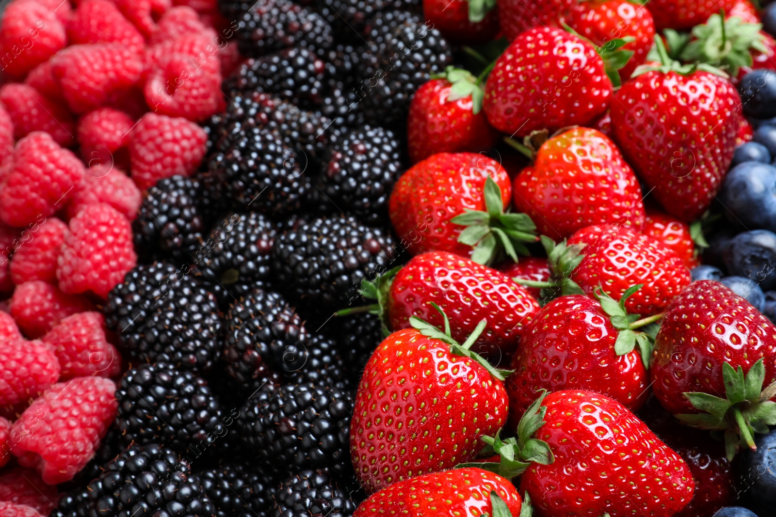 Photo of Mix of different ripe tasty berries as background, closeup view