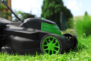 Lawn mower on green grass in garden