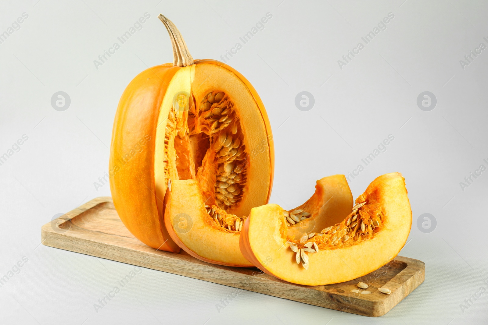 Photo of Cut fresh ripe pumpkin on white background