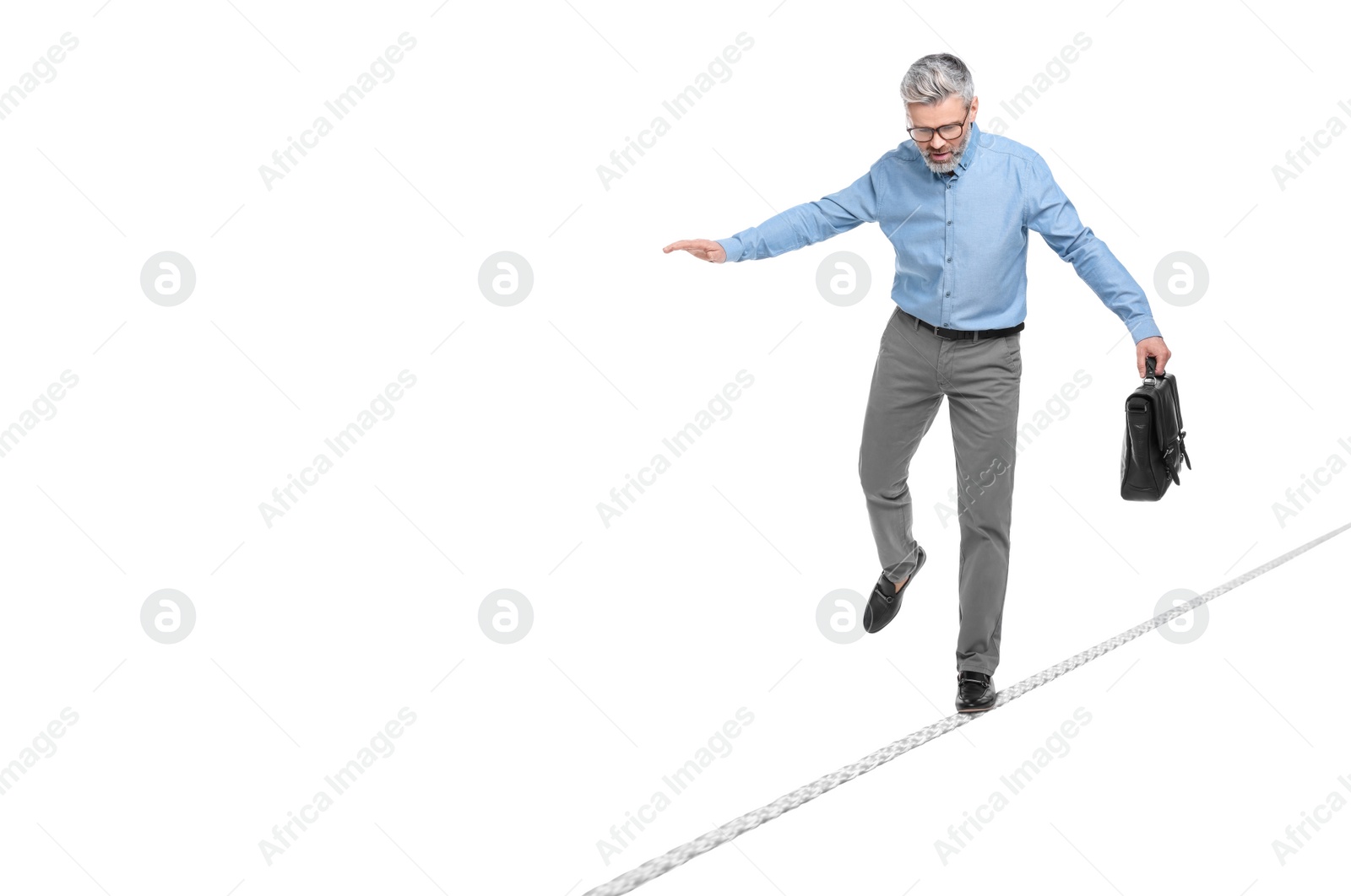 Image of Risks and challenges of owning business. Man with briefcase balancing on rope against white background