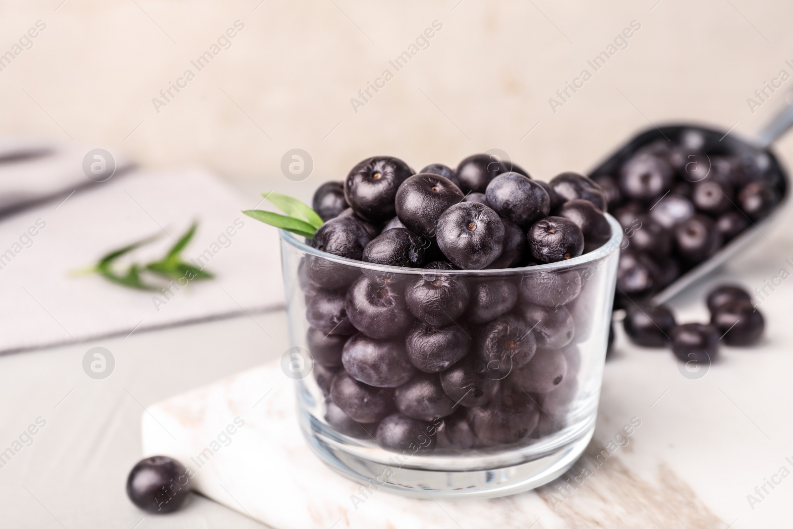 Photo of Glass of fresh acai berries on board, closeup. Space for text