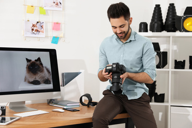 Photo of Professional photographer with camera working in light modern office