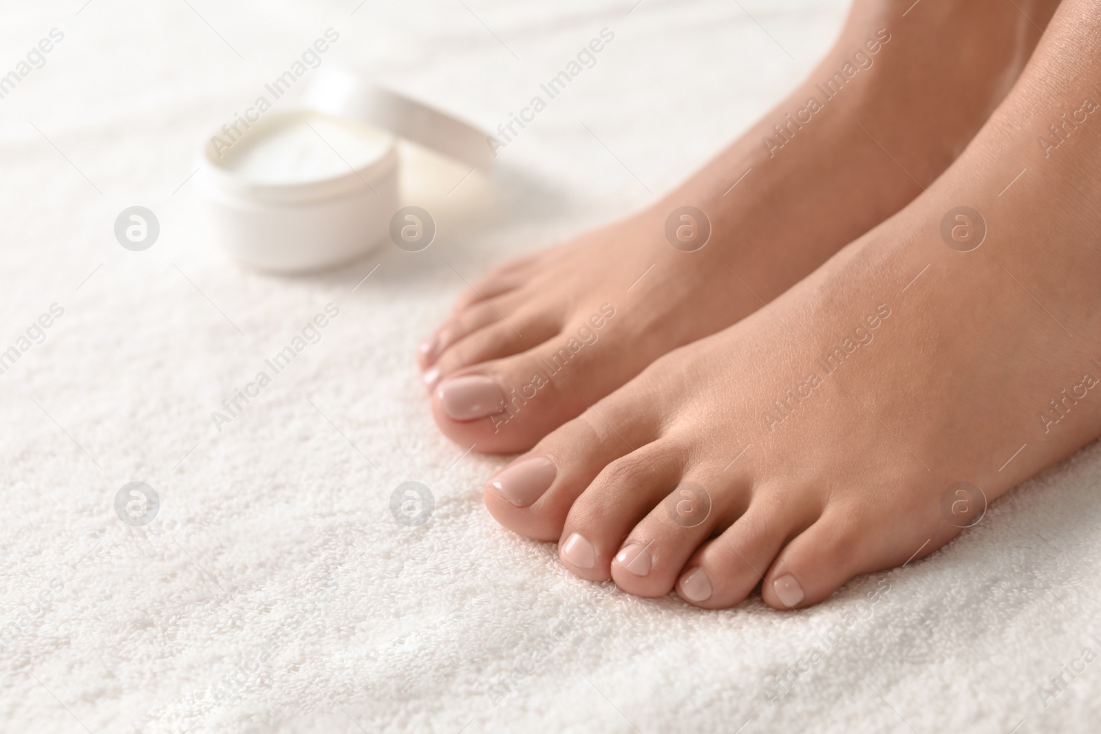 Photo of Woman with beautiful feet on white towel, closeup. Spa treatment