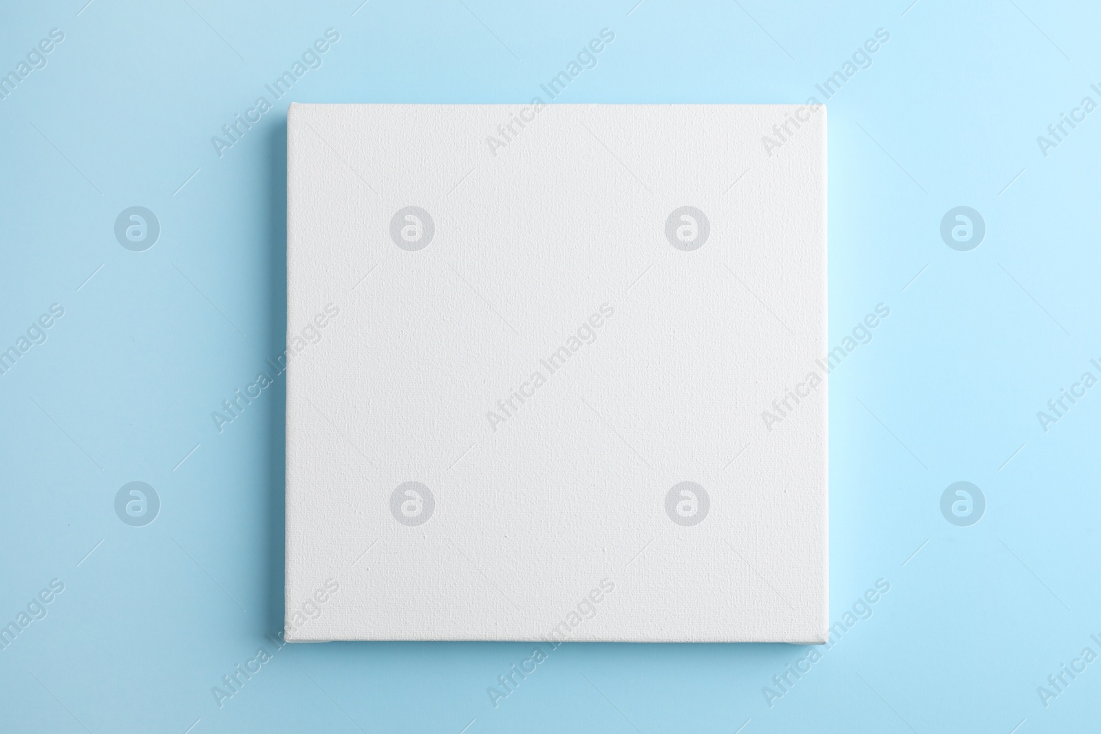 Photo of Blank canvas on light blue background, space for text