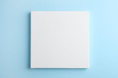 Photo of Blank canvas on light blue background, space for text