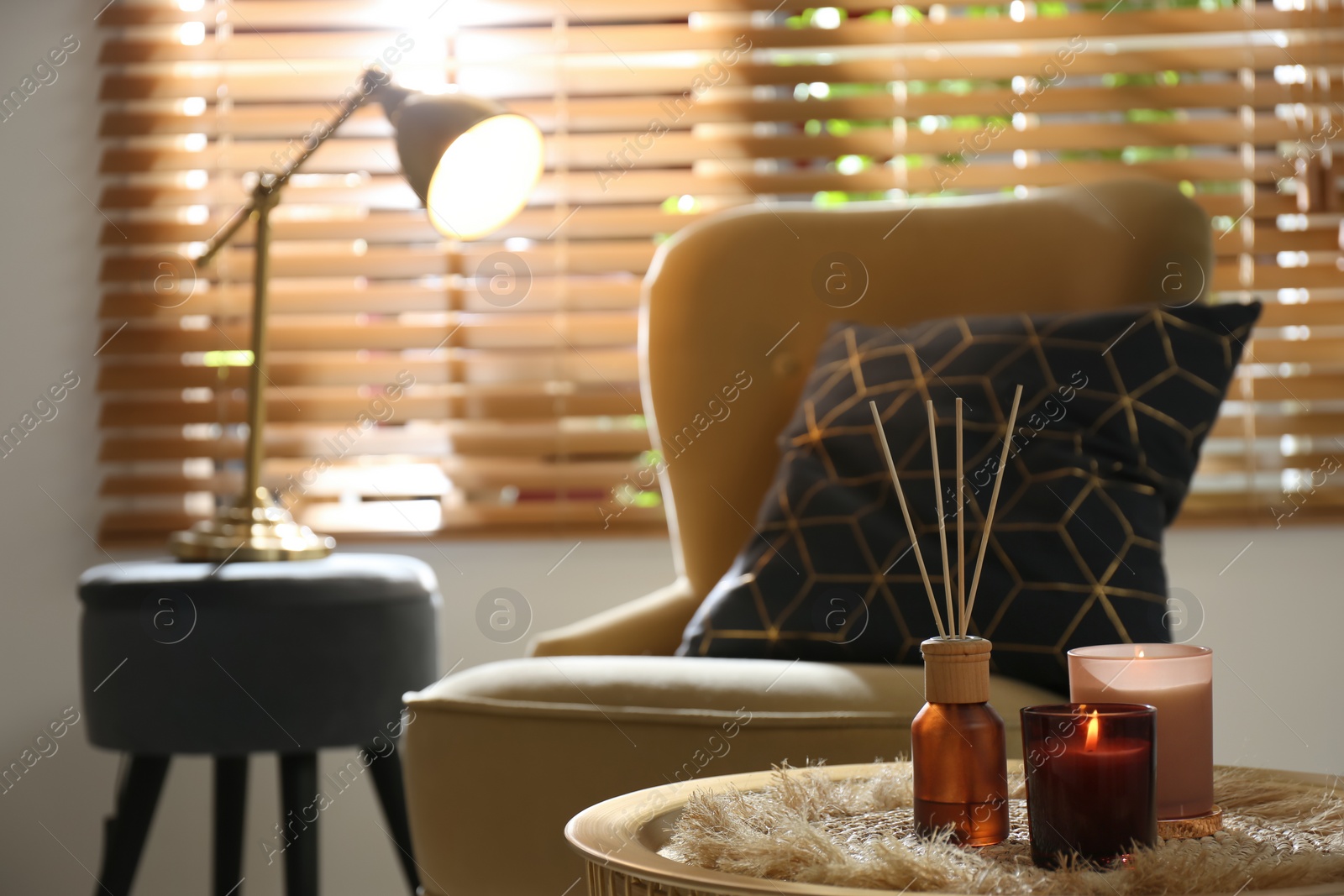 Photo of Air reed freshener and candles on table in room, space for text