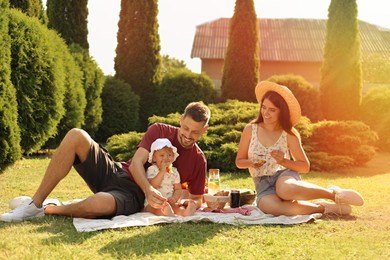 Photo of Happy family having picnic in garden on sunny day