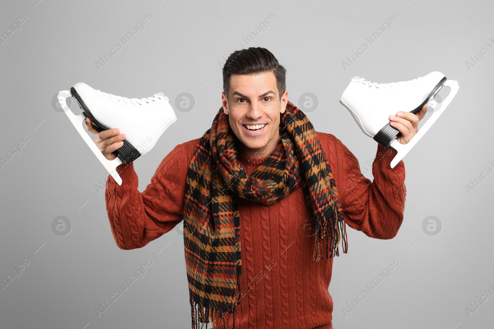 Photo of Emotional man with ice skates on grey background