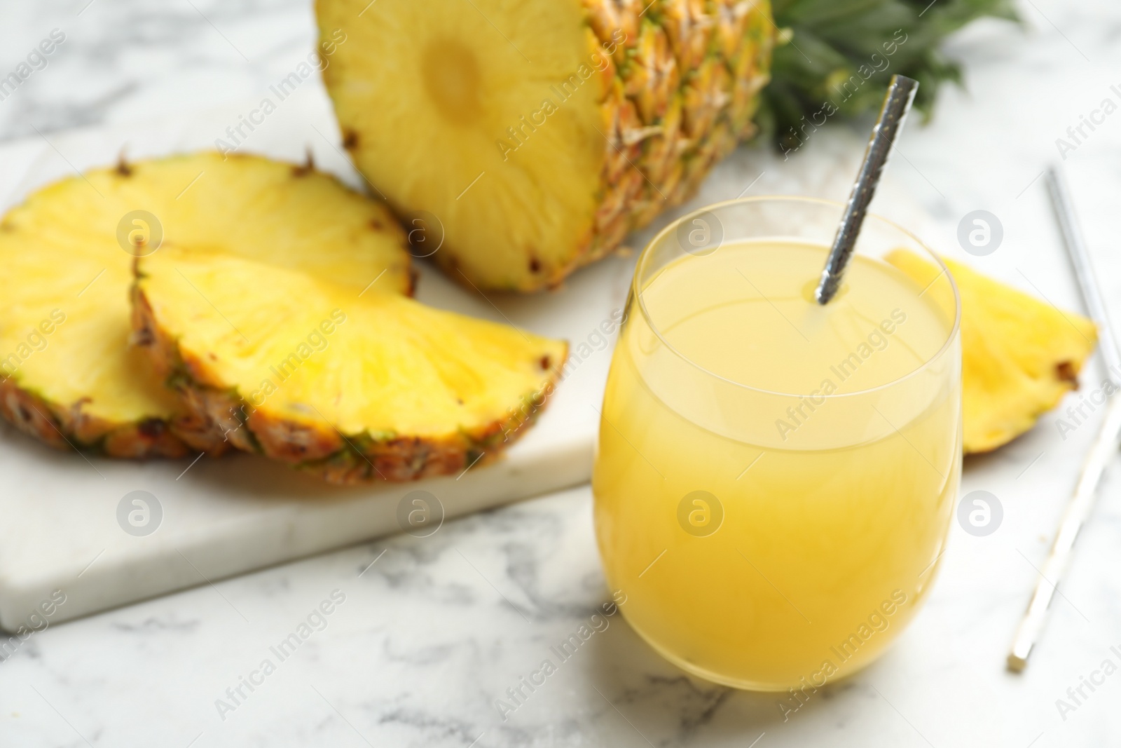 Photo of Delicious pineapple juice and fresh fruit on white marble table