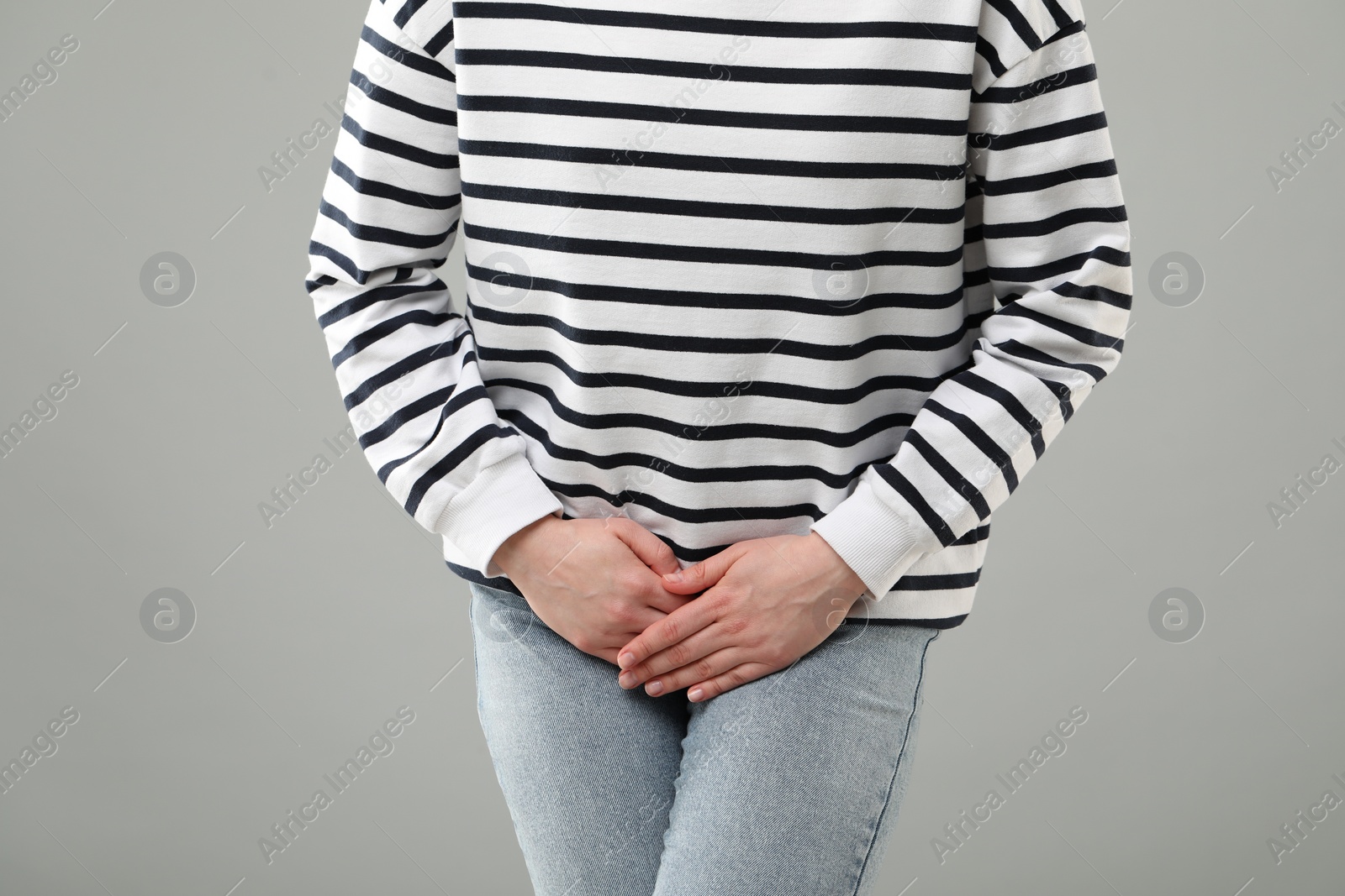 Photo of Woman suffering from cystitis on grey background, closeup