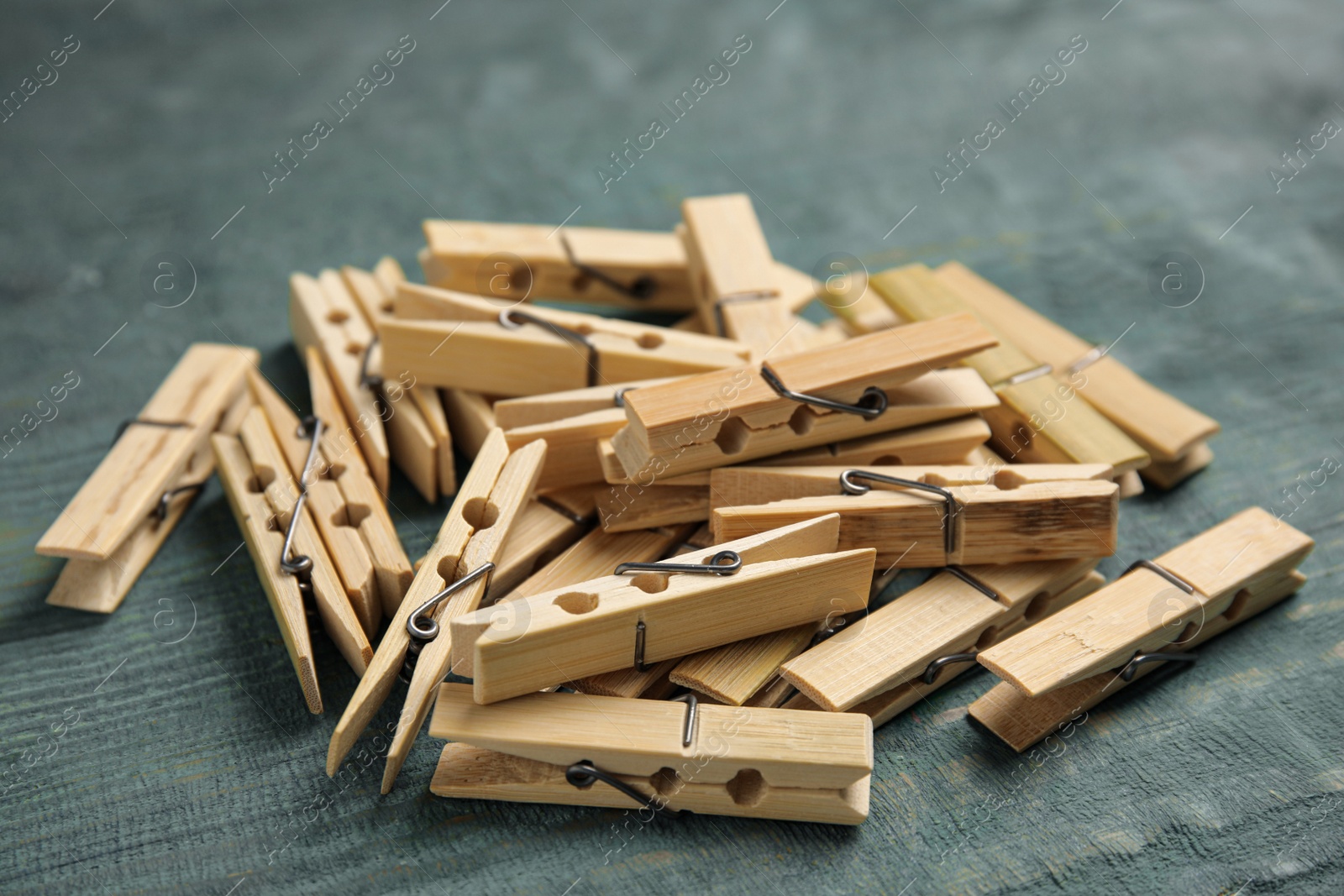 Photo of Pile of clothes pins on blue wooden table