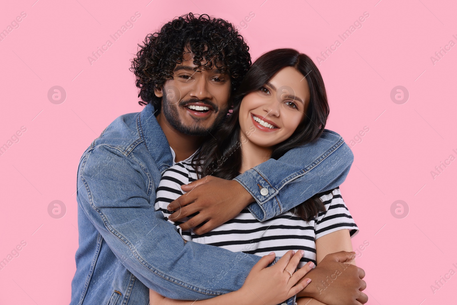 Photo of International dating. Lovely couple hugging on pink background