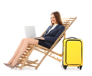 Photo of Young businesswoman with laptop and suitcase on sun lounger against white background. Beach accessories