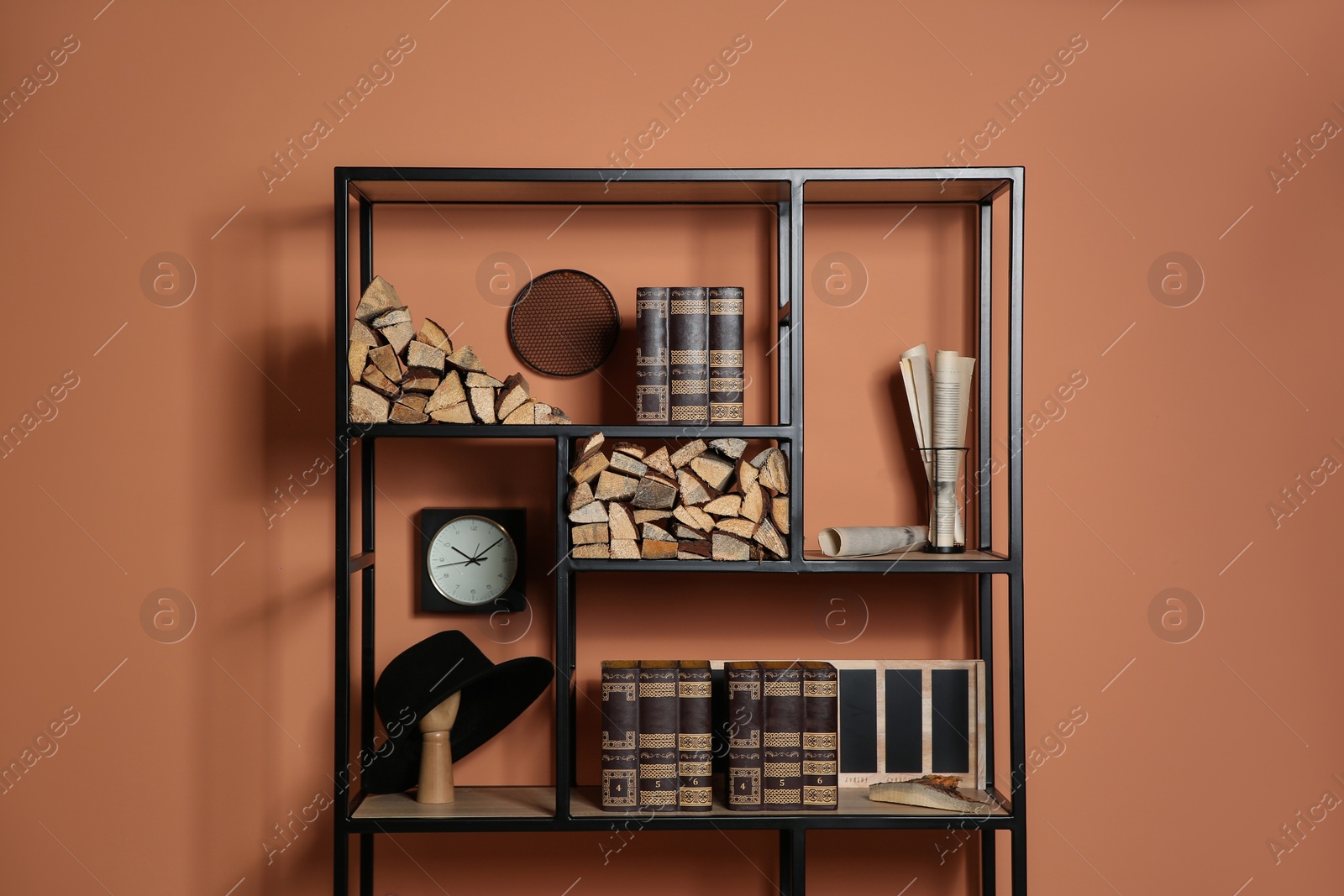 Photo of Stylish shelving unit with decorative elements near color wall. Interior design