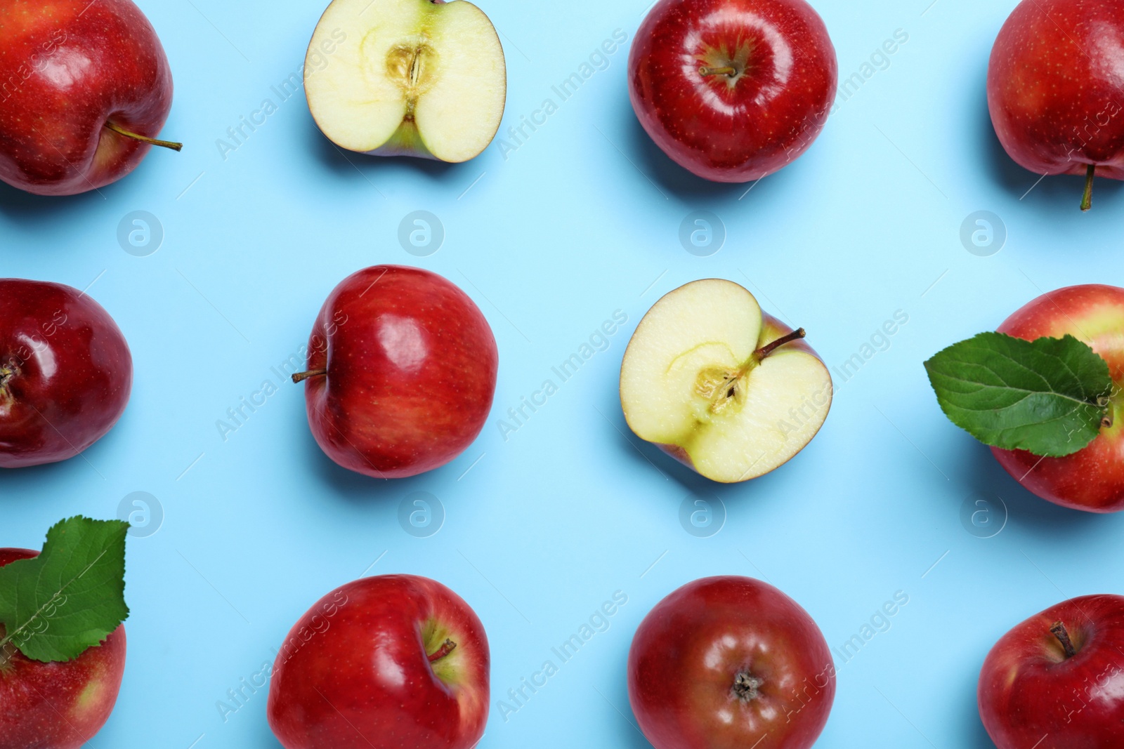 Photo of Tasty red apples on light blue background, flat lay