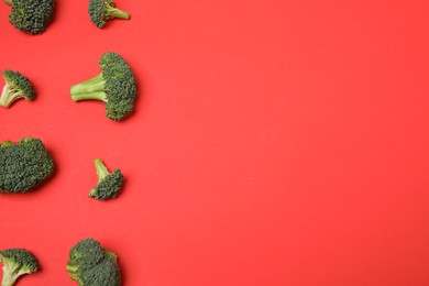 Fresh tasty broccoli on red background, flat lay. Space for text