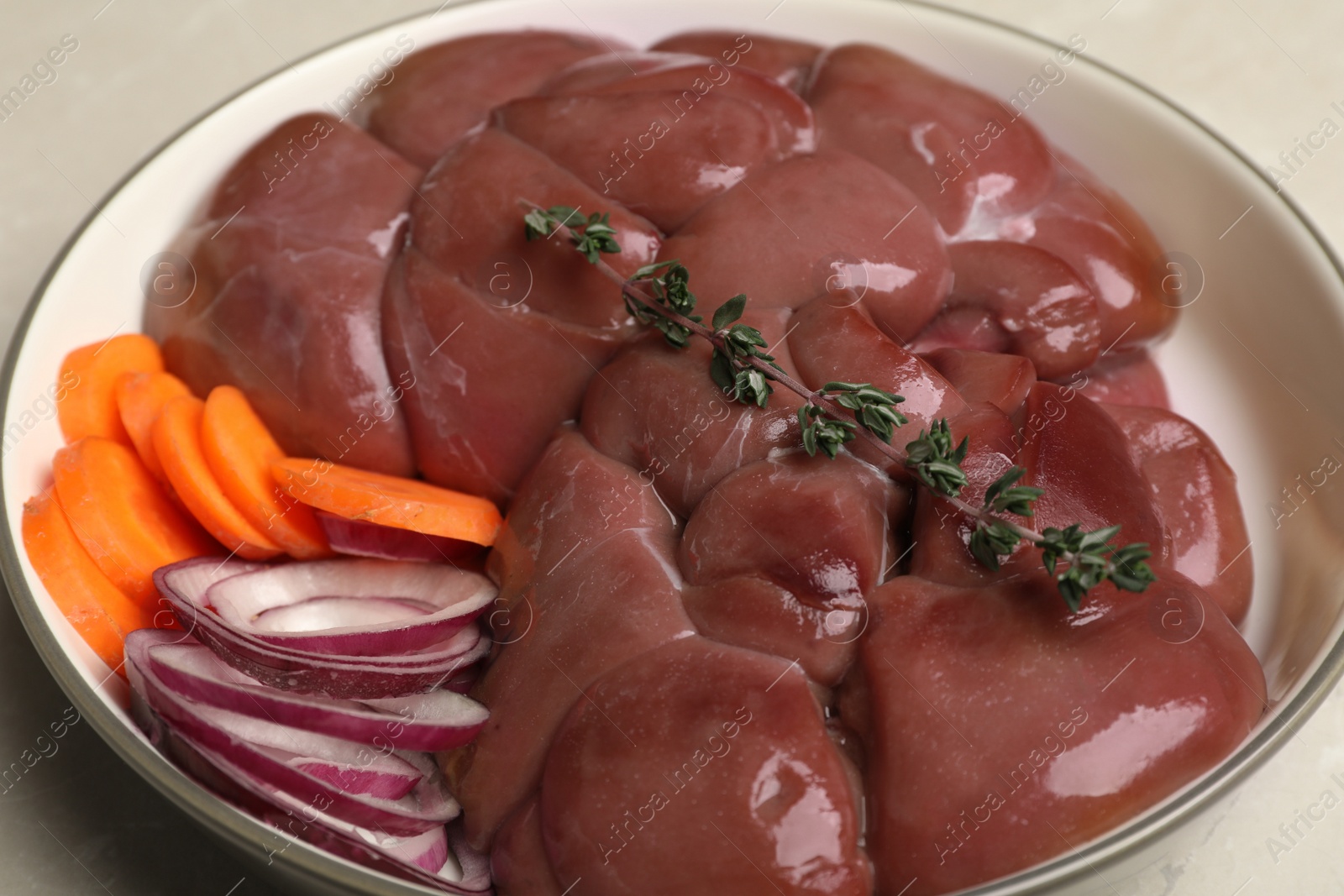 Photo of Fresh raw kidney meat with vegetables in bowl, closeup