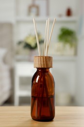 Aromatic reed air freshener on wooden table in room