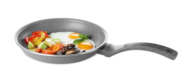 Photo of Tasty fried eggs with vegetables in pan isolated on white
