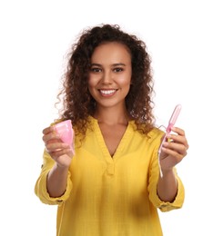 Young African American woman with menstrual cup and tampon on white background