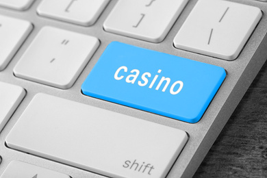 Image of Computer keyboard with button Casino on table, closeup. Online games concept