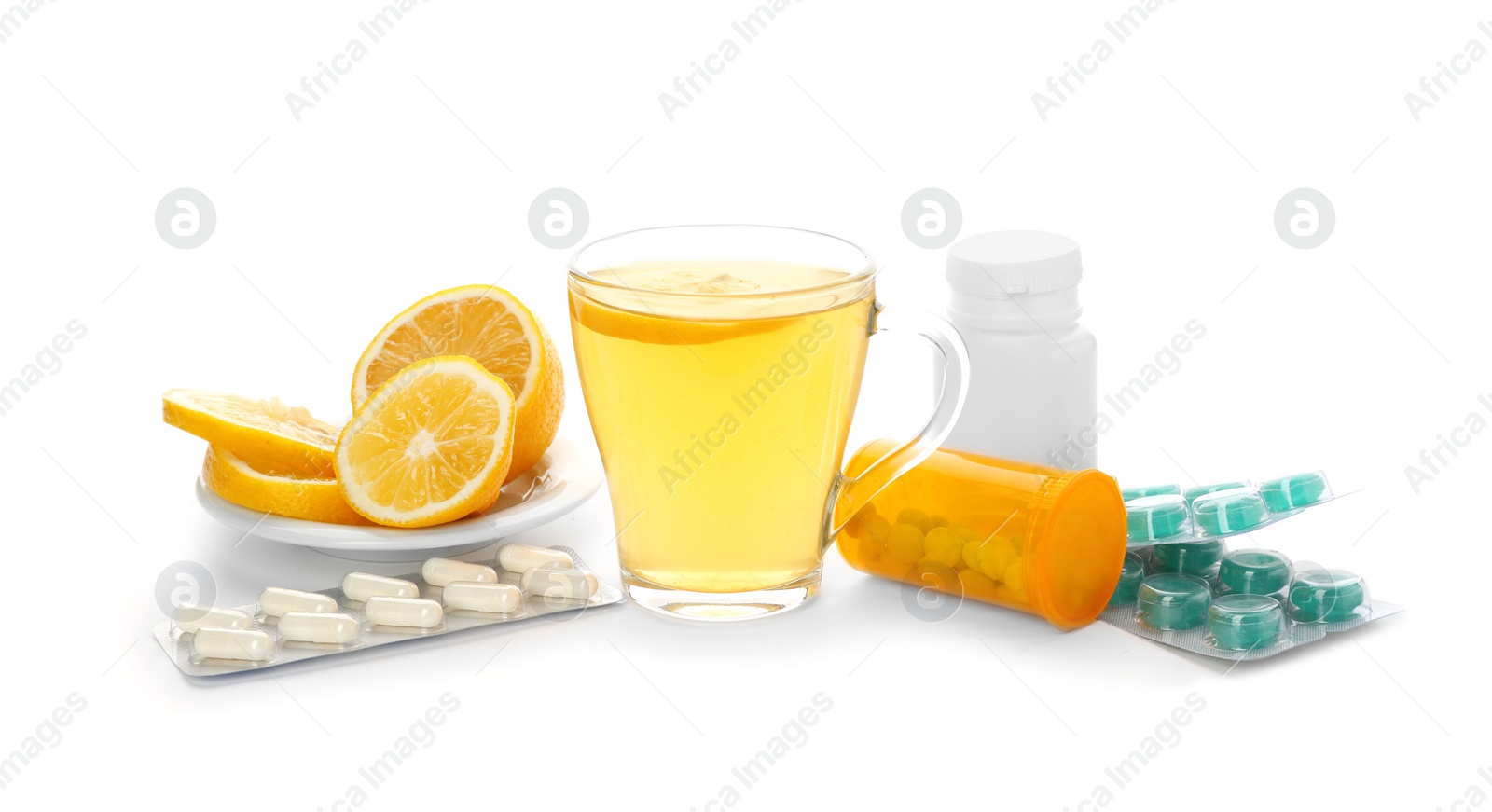 Photo of Hot tea with lemon, pills and drugs for cold on white background