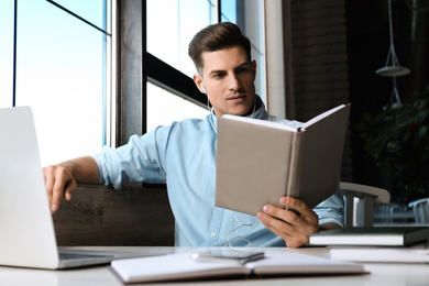 Man listening to audiobook at table in cafe