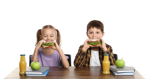 Photo of Happy children with healthy food for school lunch at desk on white background