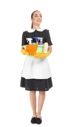 Young chambermaid holding plastic basin with detergents on white background