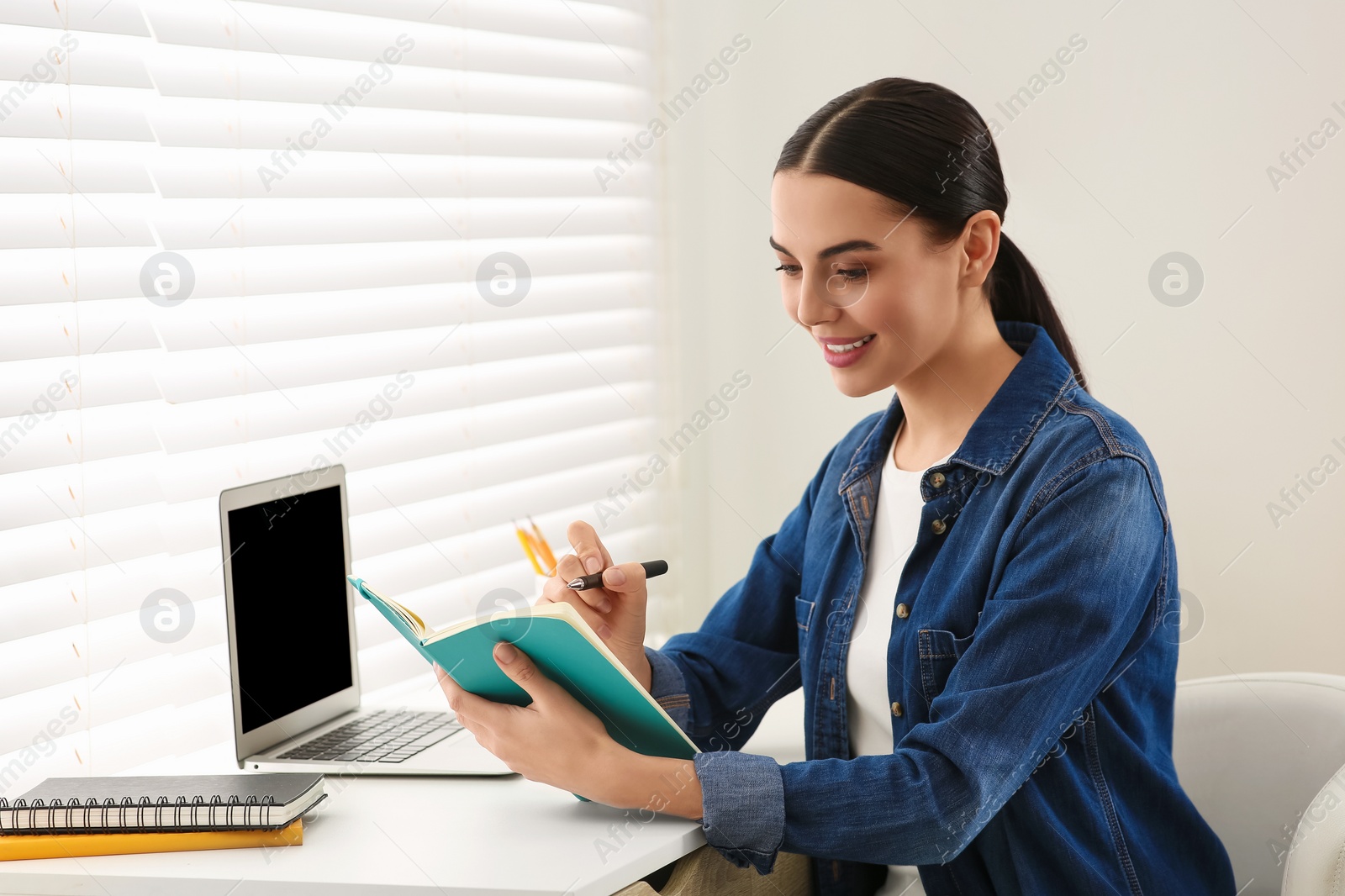 Photo of Woman studying on laptop at home. Online translation course