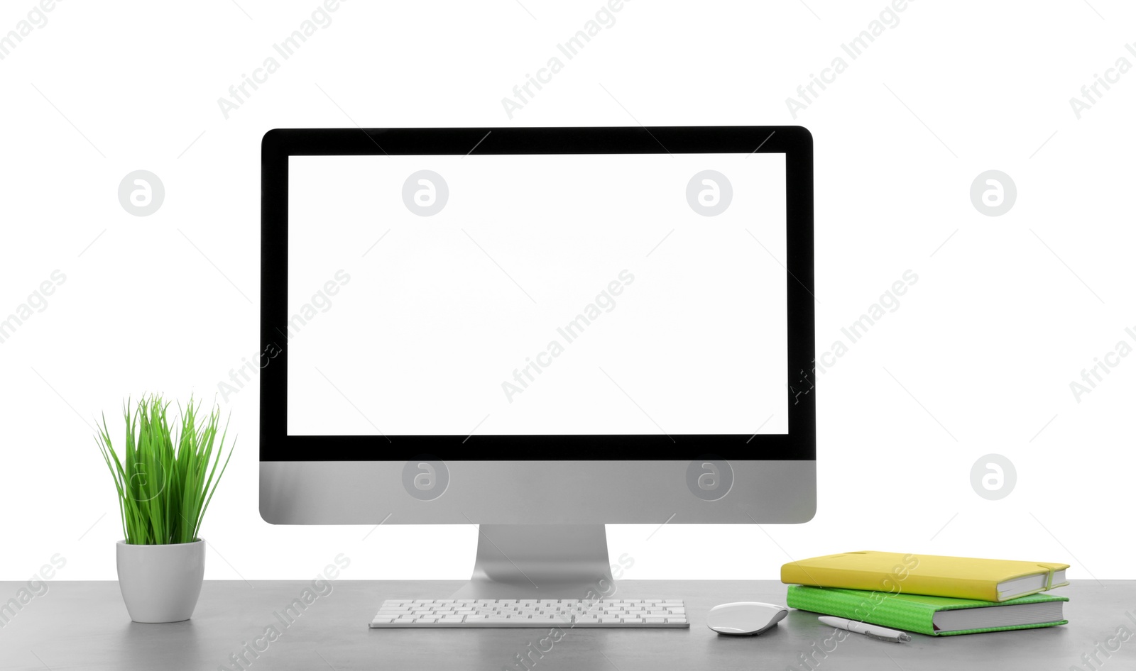 Photo of Computer, potted plant and notebooks on table against white background. Stylish workplace