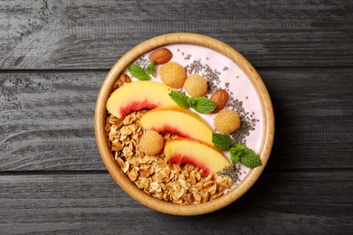 Photo of Tasty homemade granola with yogurt on grey wooden table, top view. Healthy breakfast