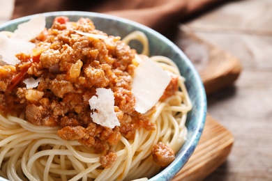 Photo of Bowl with delicious pasta bolognese on table, closeup