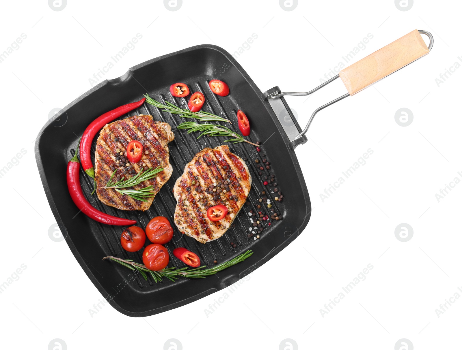 Photo of Grill pan with delicious pork steaks, spices and vegetables isolated on white, top view