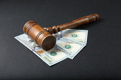 Law gavel with dollars on grey table