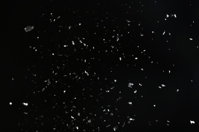 Photo of Snow flakes falling on black background. Winter weather